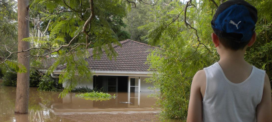 Young boy looking at flooded house