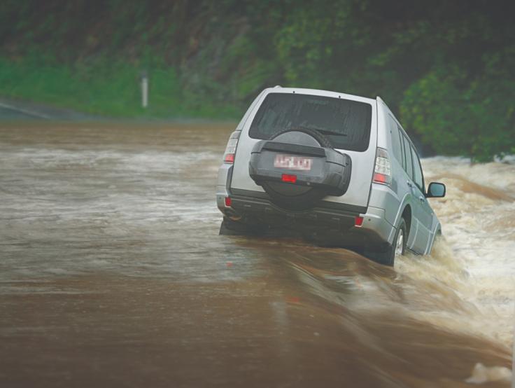 Car skidding off the road in floodwater