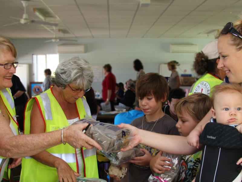 Volunteers handing ration pack to community member