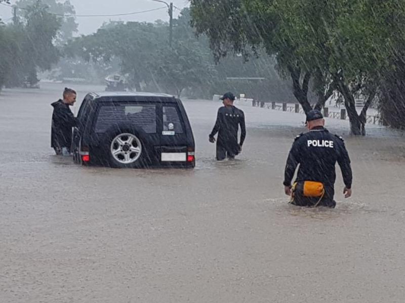 SUV stuck in floodwater with rescuers approaching