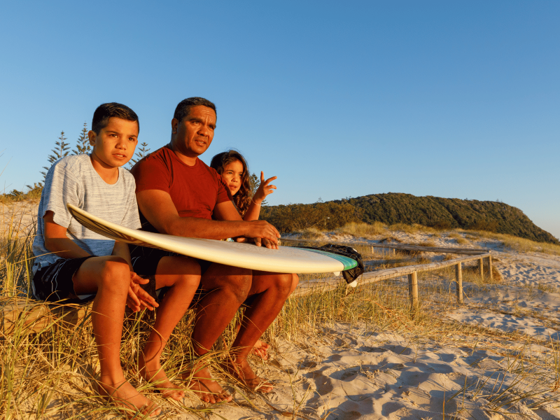 Family at Queensland beach with surfboards