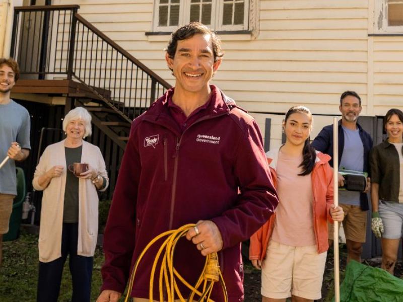 Queenslanders getting ready in front of a Queenslander styled house 